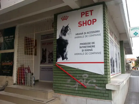 Firma albă cu PET SHOP roșu: hrană și accesorii animale de companie